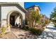 Inviting front entry with arched porch, neutral stucco, manicured landscaping, and charming details at 10604 Sariah Skye Ave, Las Vegas, NV 89166