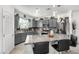 Modern kitchen boasts grey cabinets, granite countertops, stainless steel appliances, and a center island with seating at 10604 Sariah Skye Ave, Las Vegas, NV 89166