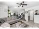 Modern living room flowing into the kitchen, featuring gray tile floors and a comfortable sectional sofa at 10604 Sariah Skye Ave, Las Vegas, NV 89166