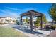 Community park with picnic tables, BBQ, playground, and lush green landscaping at 10604 Sariah Skye Ave, Las Vegas, NV 89166