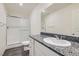 Modern bathroom featuring white vanity, granite countertop, and glass shower doors at 1163 Meadow Sparrow Pl, Henderson, NV 89011