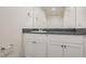 A well-lit bathroom featuring a granite countertop, white cabinets, and chrome fixtures at 1163 Meadow Sparrow Pl, Henderson, NV 89011
