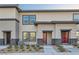 Charming townhome with stucco exterior, dark trim, and well-maintained landscaping at 1163 Meadow Sparrow Pl, Henderson, NV 89011