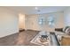 Bright living room with wood floors, neutral walls, and modern round glass coffee table at 1163 Meadow Sparrow Pl, Henderson, NV 89011