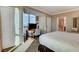 Bright bedroom featuring a queen-size bed, media center, large windows and access to the bathroom at 145 E Harmon Ave # 2021, Las Vegas, NV 89109