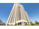 Expansive high-rise condo exterior with grand entrance and lush landscaping against a bright blue sky at 145 E Harmon Ave # 2021, Las Vegas, NV 89109