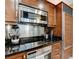 Close up of kitchenette with stainless appliances and dark wood cabinets at 145 E Harmon Ave # 2021, Las Vegas, NV 89109