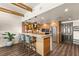 Open kitchen area showcasing a breakfast bar with stools, wood cabinets, modern lighting, and stainless steel appliances at 150 Las Vegas Blvd # 2015, Las Vegas, NV 89101