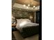 Spacious bedroom with brick accent wall, modern chandelier, and city views through large windows at 150 Las Vegas Blvd # 2015, Las Vegas, NV 89101