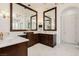 Elegant bathroom with marble countertops, dual sinks, dark wood cabinetry, and oversized decorative mirrors at 1704 Wincanton Dr, Las Vegas, NV 89134