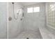 Walk-in shower featuring dual shower heads, a built-in bench, white marble tiling, and glass block window at 1704 Wincanton Dr, Las Vegas, NV 89134