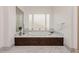 Spa-like bathroom featuring a soaking tub with marble surround and decorative privacy glass block windows at 1704 Wincanton Dr, Las Vegas, NV 89134