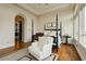 Bright bedroom with hardwood floors, a four-poster bed, and a comfortable armchair at 1704 Wincanton Dr, Las Vegas, NV 89134