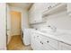 Bright laundry room featuring white cabinetry, sink, and modern appliances, perfect for efficient home management at 1704 Wincanton Dr, Las Vegas, NV 89134