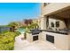 Outdoor kitchen with a grill, countertop bar, and views of the pool and palm trees at 1704 Wincanton Dr, Las Vegas, NV 89134