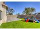 Fenced-in backyard features turf, a trampoline, a playset, and a paver patio at 1809 Lazy Hill Ranch Way, North Las Vegas, NV 89081