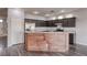 Modern kitchen with dark cabinets, granite countertops, stainless steel appliances, and a wood-paneled island at 1809 Lazy Hill Ranch Way, North Las Vegas, NV 89081