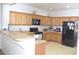 Bright kitchen featuring wood cabinets, black appliances, and a breakfast bar at 2679 Lochleven Way, Henderson, NV 89044