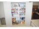 Pantry closet with shelving stocked with food and supplies and double doors at 2679 Lochleven Way, Henderson, NV 89044
