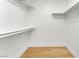 Clean walk-in closet with white walls, wooden floors, and multiple storage shelves at 2725 S Nellis Blvd # 1033, Las Vegas, NV 89121