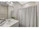 Well-lit bathroom features a shower with a geometric patterned shower curtain, and a single sink at 3164 Bormida Ave, Henderson, NV 89044