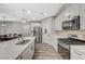 Bright kitchen features stainless steel appliances, white cabinetry, and wood-look tile flooring at 3164 Bormida Ave, Henderson, NV 89044