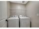 Functional laundry room equipped with a washer, dryer, and convenient overhead shelving at 3164 Bormida Ave, Henderson, NV 89044
