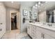 A double vanity bathroom with gray walls, white cabinets, and a walk-in closet at 3177 Bivona Walk, Henderson, NV 89044