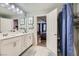 Bathroom with double sinks, white cabinets, and a connecting doorway to the bedroom at 3177 Bivona Walk, Henderson, NV 89044