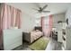 This bedroom offers modern gray plank floors, a ceiling fan, and natural light at 3177 Bivona Walk, Henderson, NV 89044