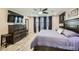 The primary bedroom features hardwood floors, a ceiling fan, and a king-size bed at 3177 Bivona Walk, Henderson, NV 89044