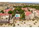 Aerial shot of a community pool area with lounge chairs and lush landscaping surrounded by charming red-roofed townhomes at 3740 Desert Marina Dr # 3, Laughlin, NV 89029