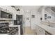 Well-lit kitchen with stainless appliances, white cabinets, and open access to other rooms at 482 Painted Sage Ct, Henderson, NV 89015