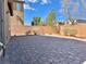Spacious backyard featuring a brick-paved area, privacy wall, and well-maintained landscaping at 486 Stonegate Meadow Ave, Las Vegas, NV 89178