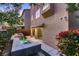 Backyard of a property with a patio, elevated tiered pool and waterfall feature, and green bushes at 6075 Belvedere Canyon Ave, Las Vegas, NV 89139
