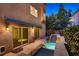 Backyard with a small patio, sliding glass doors, and elevated tiered pool with waterfall feature at 6075 Belvedere Canyon Ave, Las Vegas, NV 89139
