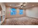 Bright and airy bedroom featuring neutral carpet, ceiling fan and large windows with natural light at 6075 Belvedere Canyon Ave, Las Vegas, NV 89139
