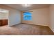 Large bedroom featuring neutral carpet and an arched window, leading to an ensuite bathroom at 6075 Belvedere Canyon Ave, Las Vegas, NV 89139