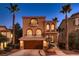 Beautiful two-story home featuring arched windows and private balconies with a two car garage and desert landscaping at 6075 Belvedere Canyon Ave, Las Vegas, NV 89139