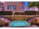 Exterior image of the backyard pool, with waterfall features, landscaping, and nearby townhouse architecture at 6075 Belvedere Canyon Ave, Las Vegas, NV 89139