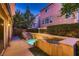 Backyard pool with tiered waterfall feature between homes and green bushes surrounding the elevated feature at 6075 Belvedere Canyon Ave, Las Vegas, NV 89139