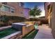 Backyard pool with small retaining wall and tiered waterfall between townhouse style properties with small patches of turf grass at 6075 Belvedere Canyon Ave, Las Vegas, NV 89139