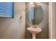 Charming powder room with pedestal sink, stylish mirror, and modern fixtures at 6075 Belvedere Canyon Ave, Las Vegas, NV 89139