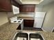 Condo kitchen featuring granite countertops, white appliances, and dark cabinets at 6800 E Lake Mead Blvd # 1018, Las Vegas, NV 89156