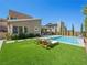Lush backyard features a refreshing pool, green grass, and stylish lounge chairs for ultimate relaxation at 7222 Pulsar Mesa Ct, Las Vegas, NV 89148