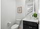 A well-lit half bathroom with a stylish mirror, modern sink and toilet at 7222 Pulsar Mesa Ct, Las Vegas, NV 89148