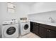 The laundry room features front loading washer and dryer, sink, cabinets and a window at 7222 Pulsar Mesa Ct, Las Vegas, NV 89148