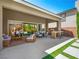 Outdoor patio with seating, a built-in grill, and easy access to a lush backyard and pool area at 7222 Pulsar Mesa Ct, Las Vegas, NV 89148