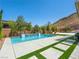 Resort-style pool with a waterfall feature, spacious deck, and artificial turf, perfect for outdoor entertaining at 7222 Pulsar Mesa Ct, Las Vegas, NV 89148