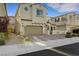 Well-kept, tan two-story home with desert landscaping, brick driveway, and arched entryway at 8043 Tank Loop St, Las Vegas, NV 89166